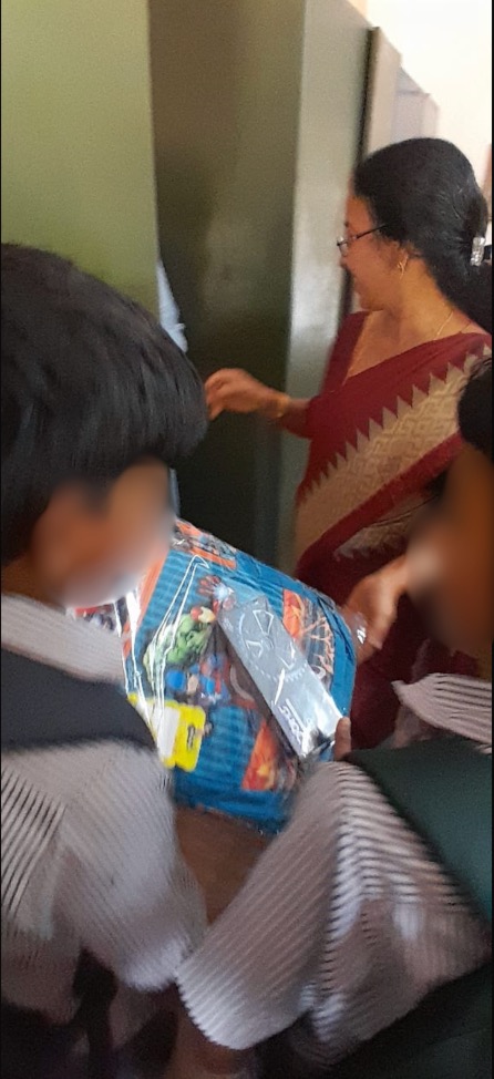 Child receiving school supplies from a teacher